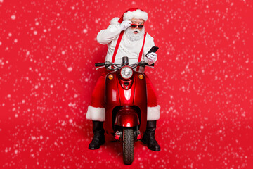 Portrait of nice attractive bearded shocked funny funky Santa wearing cap hat sitting on motor bike...