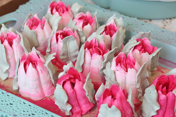 Marshmallow tulips. Marshmallow flowers. Spread out on the table surface. Close-up.