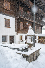 While it snows. Under a heavy snowfall walking in the village of Cima Sappada