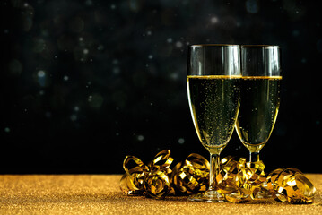 Happy new year. Champagne glasses with golden streamers and space for text. New Years Eve...