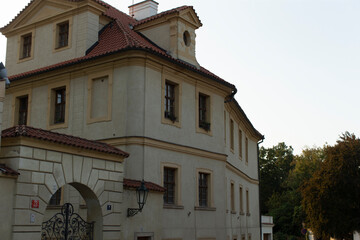 A large and impressive white building adorned with a charming red tile roof, creating a picturesque scene against the backdrop of nature