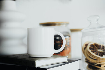 Cozy morning ambiance with a white mug, books, and dried fruits on a table