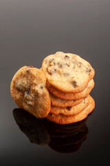 A plate of homemade chocolate chip cookies black background