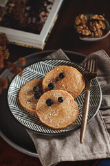 Pumpkin pancakes on a plate. Pancakes with blueberries on a plate. Delicious breakfast on a table	