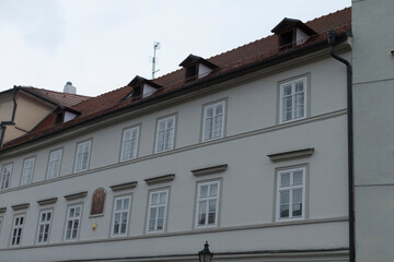 Fototapeta premium In the landscape stands a large, impressive white building, adorned with a striking red tiled roof that captures the eye of onlookers