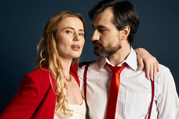 A middle aged couple showcases attraction and confidence against a dramatic backdrop.