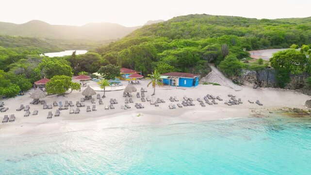 Aerial descend and orbit of Grote Knip in Curacao with turquoise waters, sandy shoreline, and tropical greenery