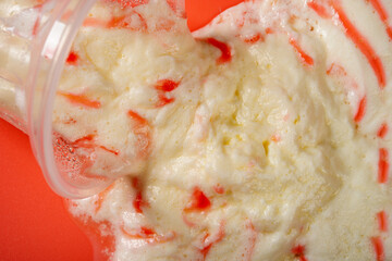 top view vanilla ice cream cup in a melting process on a red background