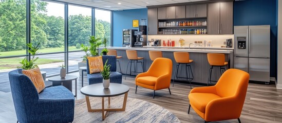 A modern office break room with orange chairs and a blue wall, a coffee bar with bar stools, and a view of the outdoors.