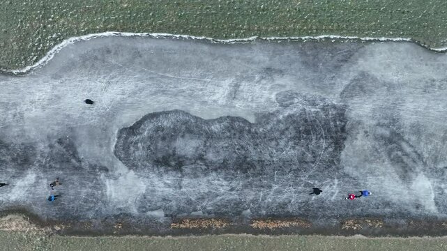 Ice skating on the Drontermeer floodplains near Elburg in nature seen from above during a cold winter day in The Netherlands.