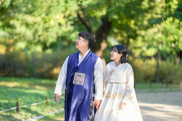 A Korean couple, a man in his 30s and a woman in her 20s, are spending time together in a historic park in Seoul, South Korea.