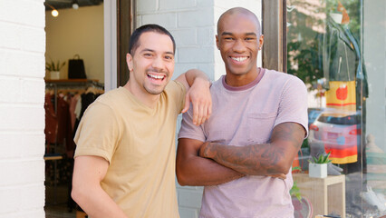 Obraz premium Portrait Of Two Smiling Male Sales Assistants Standing Outside Clothing Fashion Store