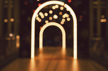 Blurred abstract image view of illuminated archways with warm glowing lights and bokeh background at night