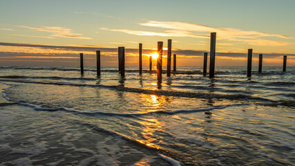 Palendorp Petten in the sea during a golden sunset. The Palendorp of Petten is a work of art and a...