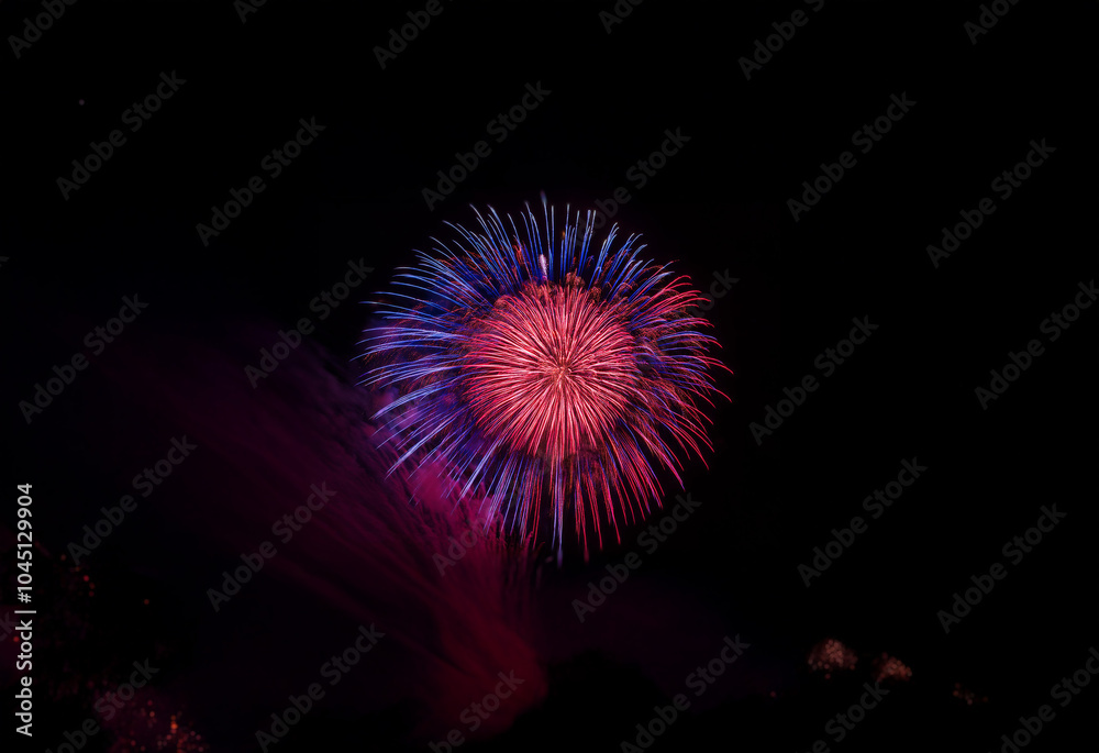 Poster a single firework bursts in a vibrant display of red and blue against a dark, isolated background.