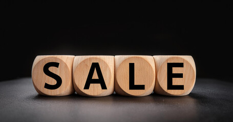 Wooden cubes with the inscription SALE on a dark background