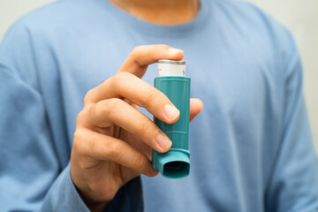 Asthma and chronic obstructive pulmonary disease COPD, Asian young man using metered dose inhaler MDI.