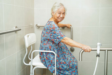 Asian elderly old woman patient use toilet support rail in bathroom, handrail safety grab bar,...