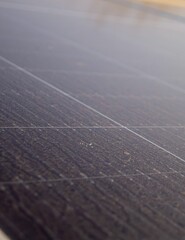 Close-up of a dusty solar panel surface with visible dirt and grid lines, illustrating challenges...