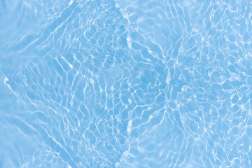 Blue water with ripples on the surface. Defocus blurred transparent blue colored clear calm water surface texture with splashes and bubbles. Water waves with shining pattern texture background.