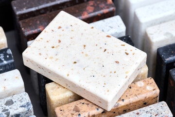 Porcelain stoneware square samples as kitchen countertop examples of future kitchen fasade exterior. Samples slabs of natural granite marble quartz for stone countertops close up.