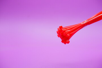 bundle of red zip ties isolated on purple background. Cable ties or cable ties, straps that can be used for various purposes.