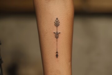 Obraz premium A minimalist arrow tattoo on the forearm, pointing forward.