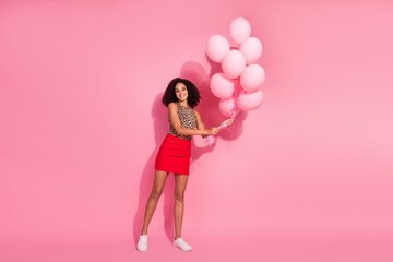 Full body photo of attractive young woman hold air balloons dressed stylish leopard print clothes isolated on pink color background
