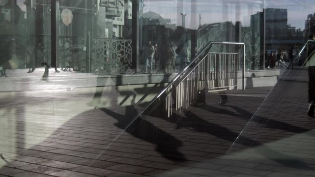 People getting in and out of the subway. Multi-layered Images of pedestrians reflected in the window. The chaos of the city and people in a hurry.