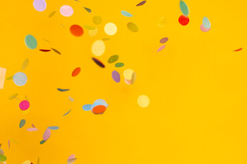 Colorful of confetti on gold background. Brilliant colored sequins. Holiday greeting card.