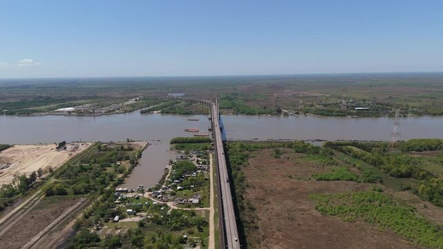 Drone view of Justo Jose de urquiza bridge above the wide Parana Guazu river, a vast waterway, and the surrounding landscape. Buenos Aires Argentina. Moving to the left