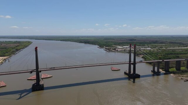 Drone view of Justo Jose de urquiza bridge above the wide Parana Guazu river, a vast waterway, Buenos Aires Argentina. Pan to the left