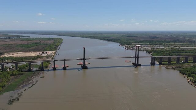 Drone view of Justo Jose de urquiza bridge above the wide Parana Guazu river, a vast waterway, Buenos Aires Argentina. Pan to the left