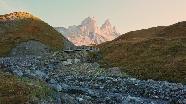 Landscape of iconic three peak mountain and stream flowing in Aiguilles d Arves among French Alps