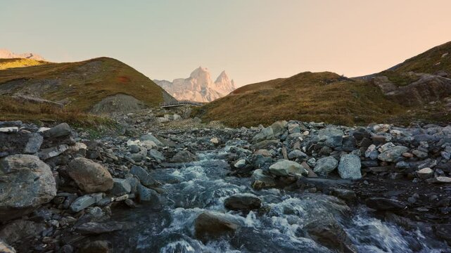 Landscape of iconic three peak mountain and stream flowing in Aiguilles d Arves among French Alps