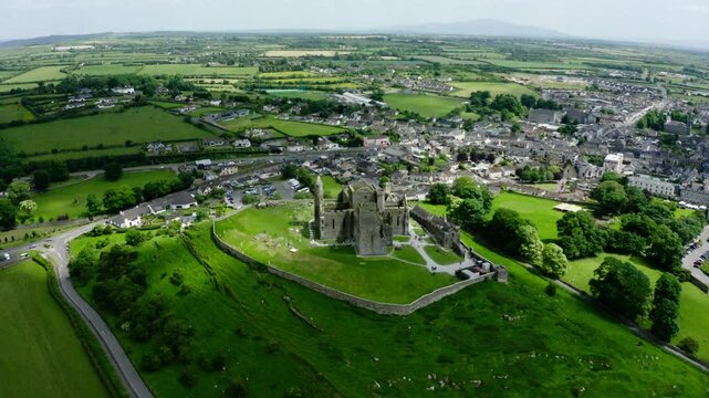 Wide drone shot over an Irish castle standing tall over the surrounding town.