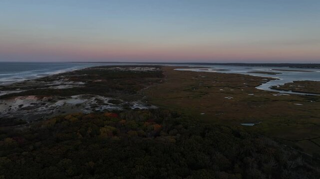 Cape cod marsh and dunes at sunset with colorful autumn foliage and water channels, aerial view