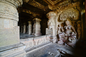 Hand sculpted stone statue of female hindu deity seated under a tree within Ellora cave complex...