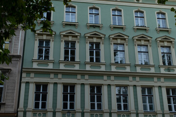 There is a striking green and white building that features an extensive array of windows, making it stand out in the cityscape