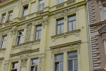 Obraz premium A bright yellow building that features an abundance of windows on its facade, giving it a charming and inviting appearance