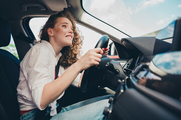 Photo of afraid funny girl wear white shirt smiling riding vehicle test drive car outdoors urban...