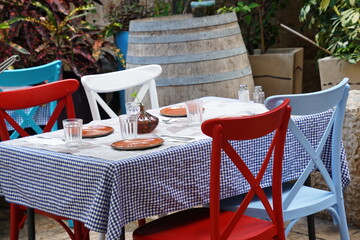 Exterior design of a summer cafe with a laid out table ready for lunch, with colorful chairs