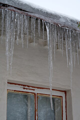 Large long icicles hang from roof of house