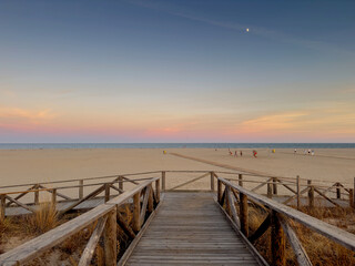 Arrival view of the beach with sunset. With wooden jetty.