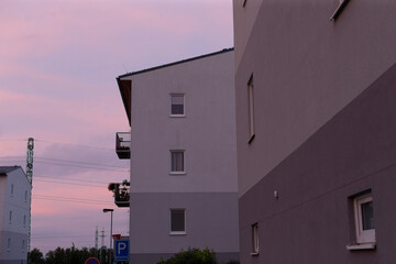 A beautiful building stands majestically with a stunning pink sky as its backdrop, creating a captivating view of the scene around it