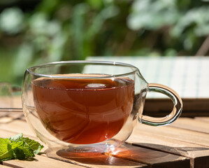 Cup of tea and mint on wooden table