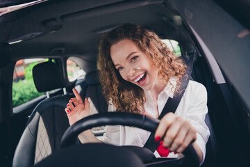 Naklejka premium Photo of adorable lovely girl wear white shirt singing riding vehicle enjoying test drive outdoors urban city street