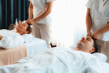 Obraz premium Caucasian couple enjoying relaxing anti-stress head massage and pampering facial beauty skin recreation leisure in dayspa modern light ambient at luxury resort or hotel spa salon. Quiescent