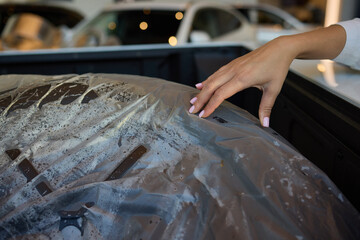 Closeup view of a hand resting on a covered tire within a vehicles interior space