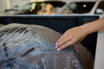 Fototapeta premium Closeup view of a hand resting on a covered tire within a vehicles interior space